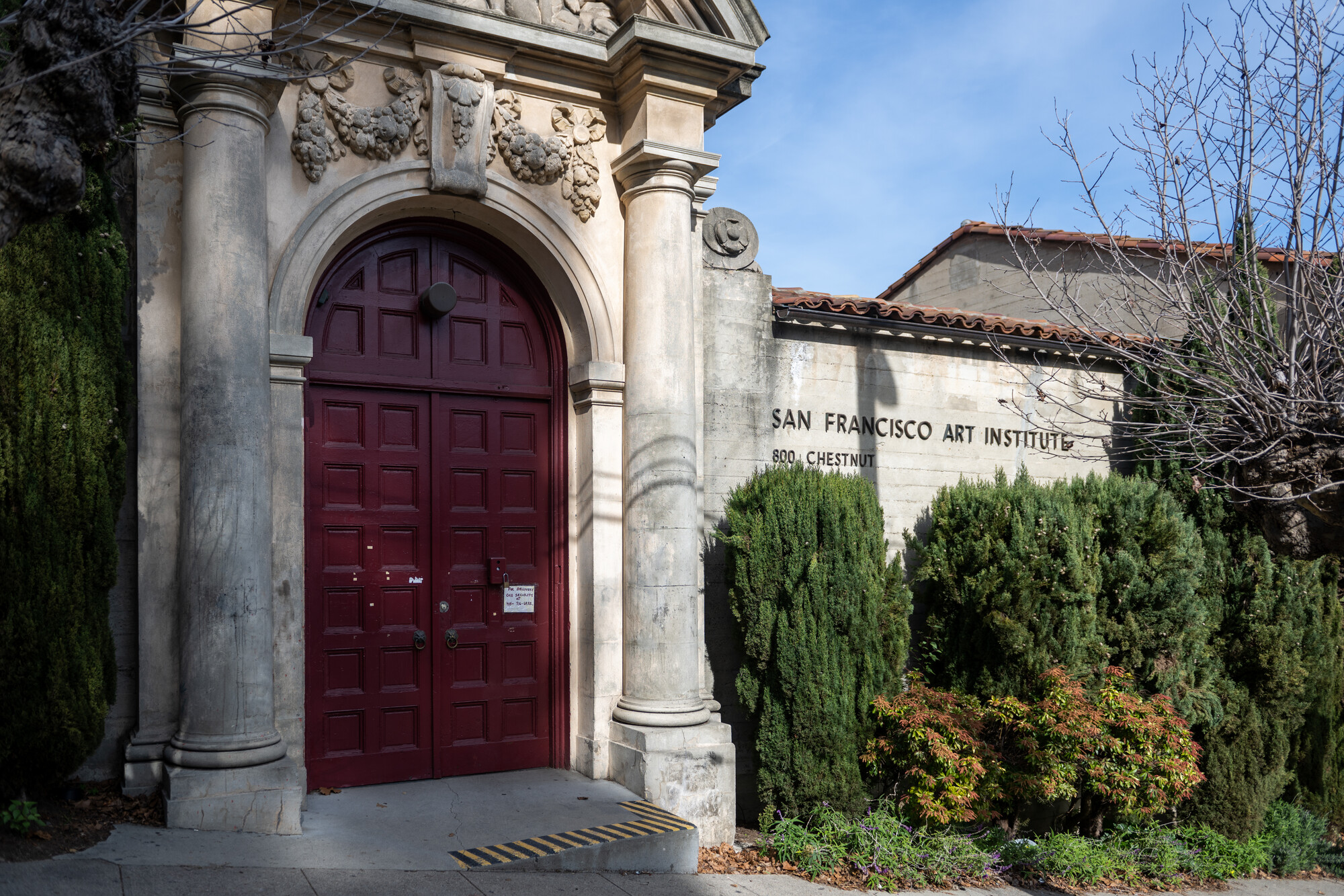 large wooden doors of building exterior with school name on wall