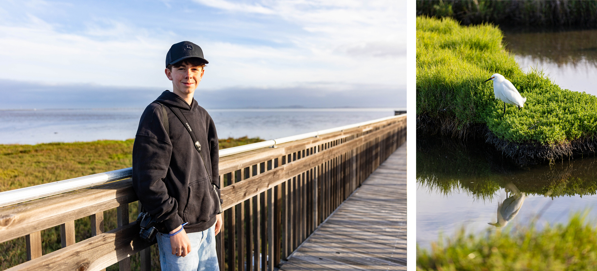 young person in cap smiles on wooden boardwalk overlooking wetlands, at right, white wading bird reflected in water
