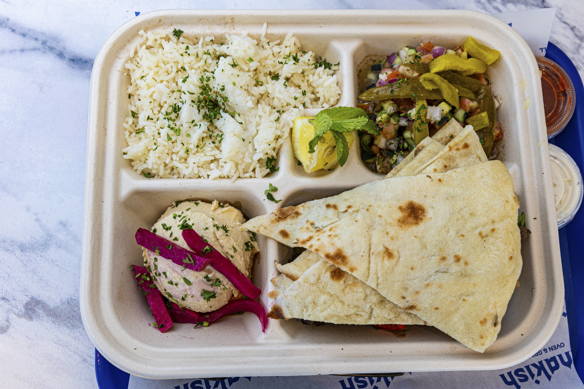 Overhead view of a kefta kebab plate with rice and flatbread.