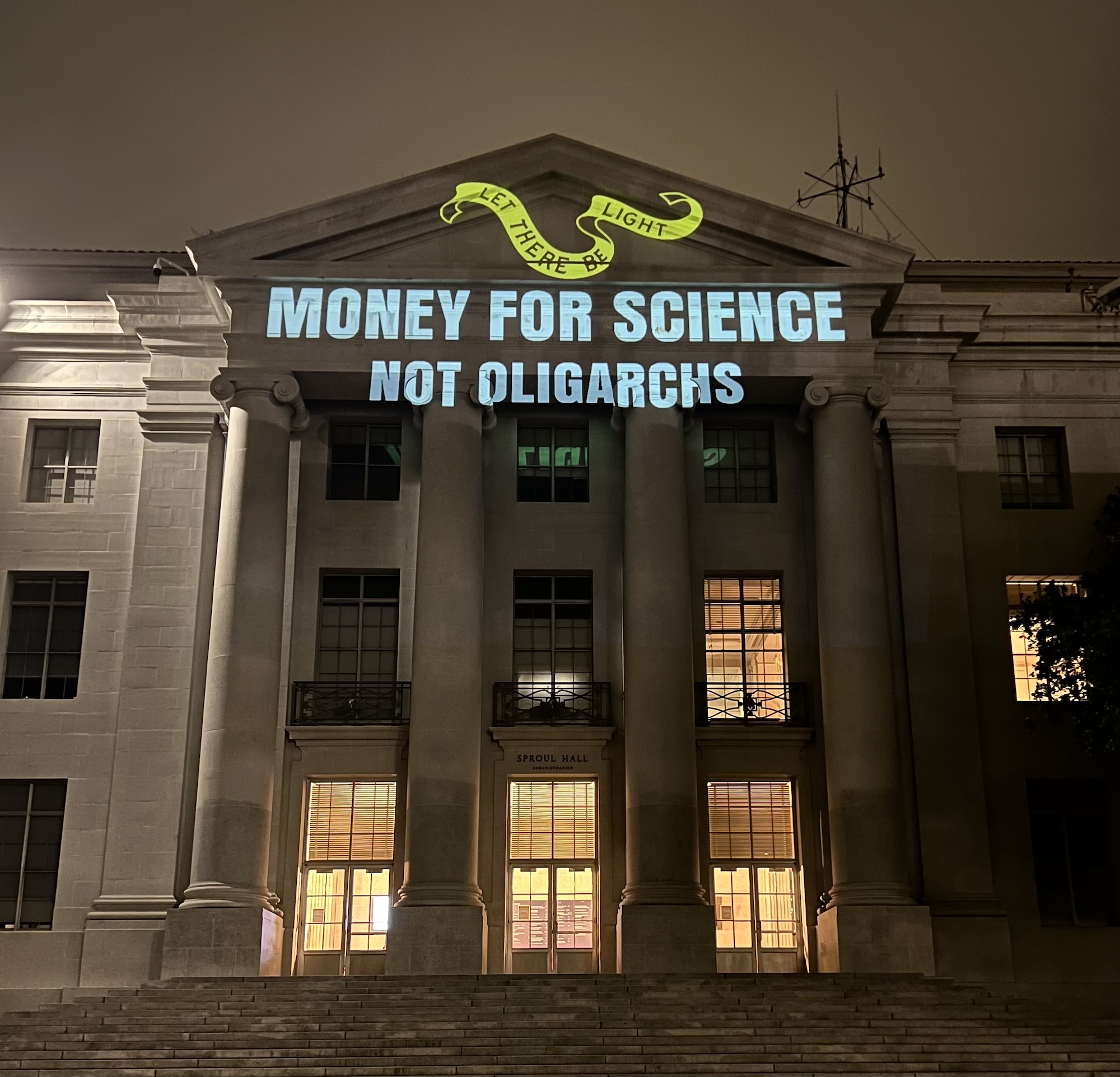 A projection reading ‘Money for science, not oligarchs’ on a building at UC Berkeley.
