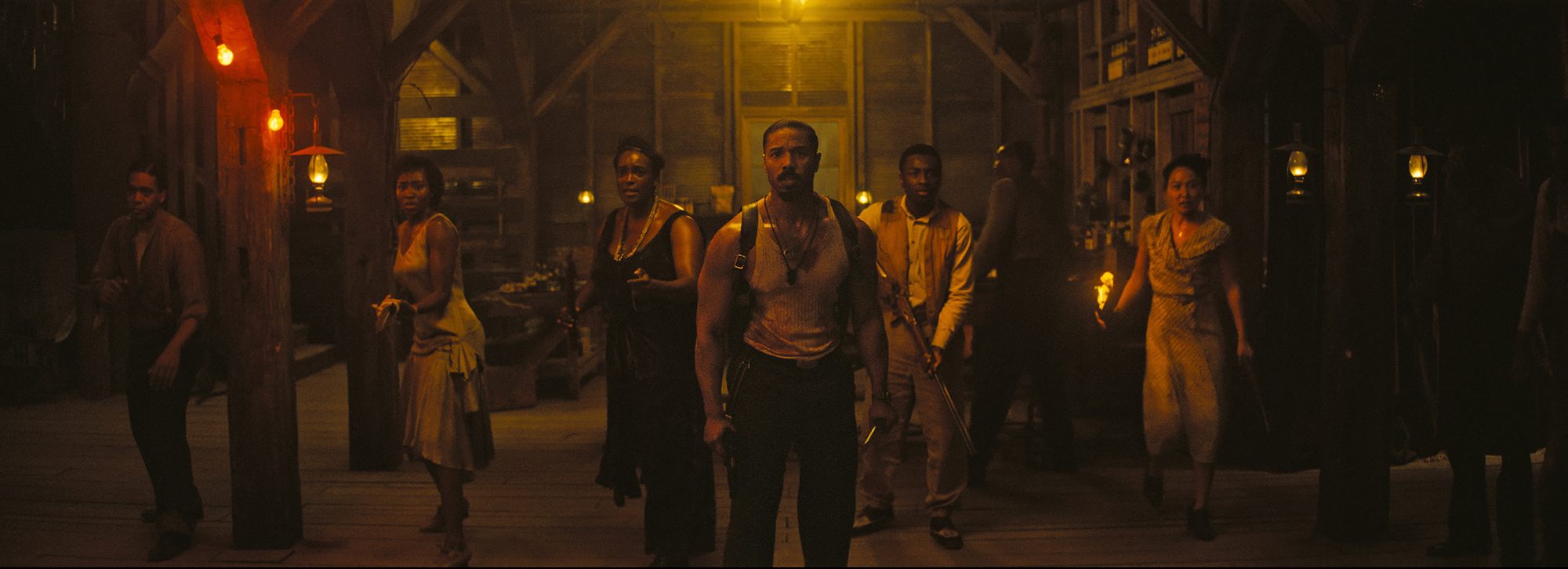 A group of people prepare for battle inside a dimly lit juke joint.