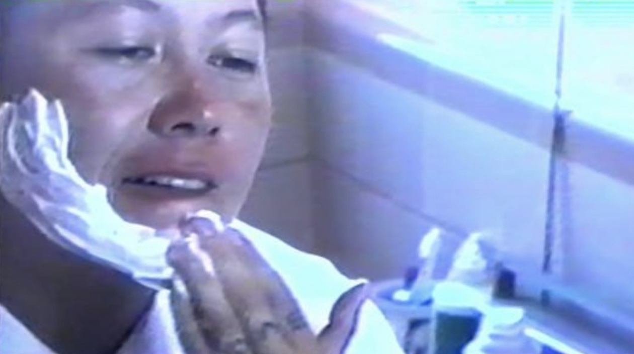 person applying shaving cream in bathroom