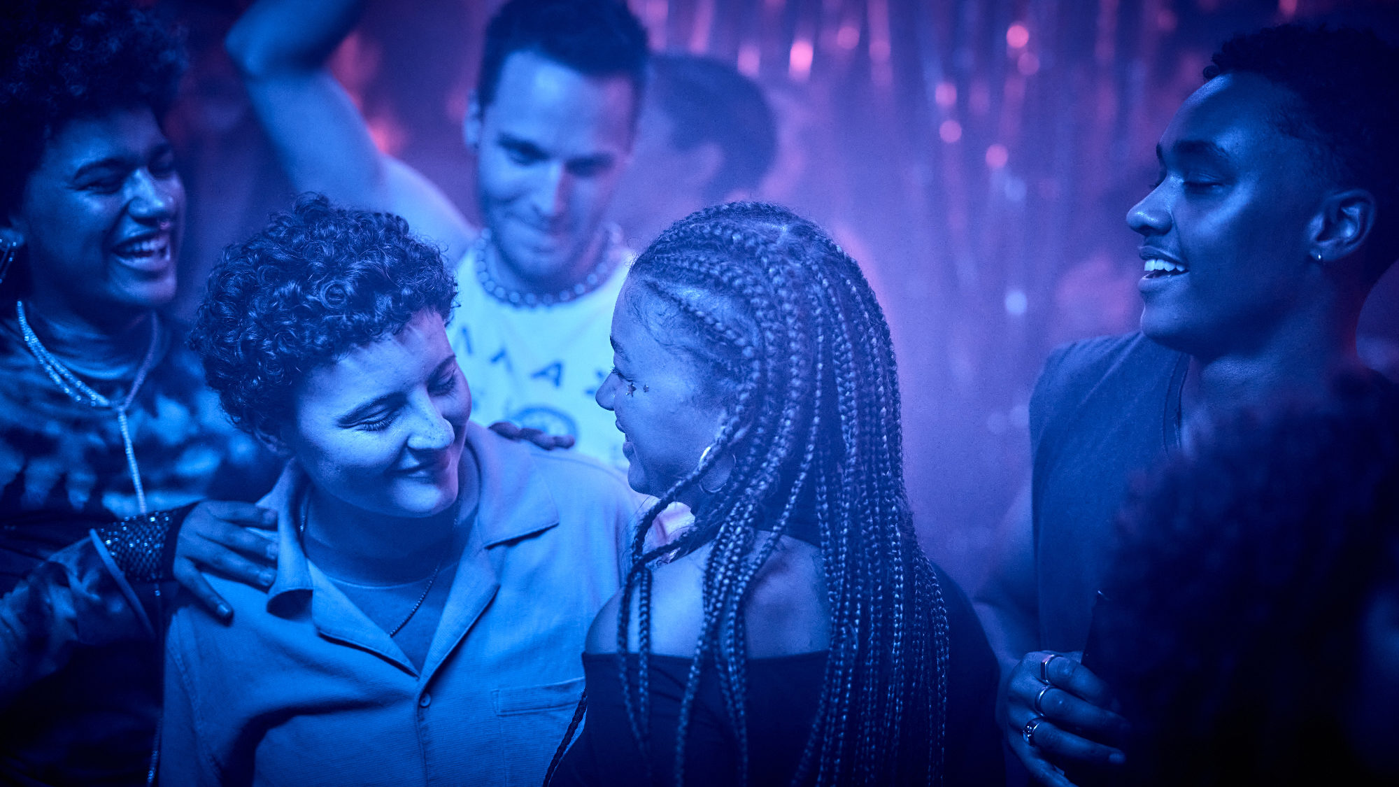 blue-lit young people in party scene
