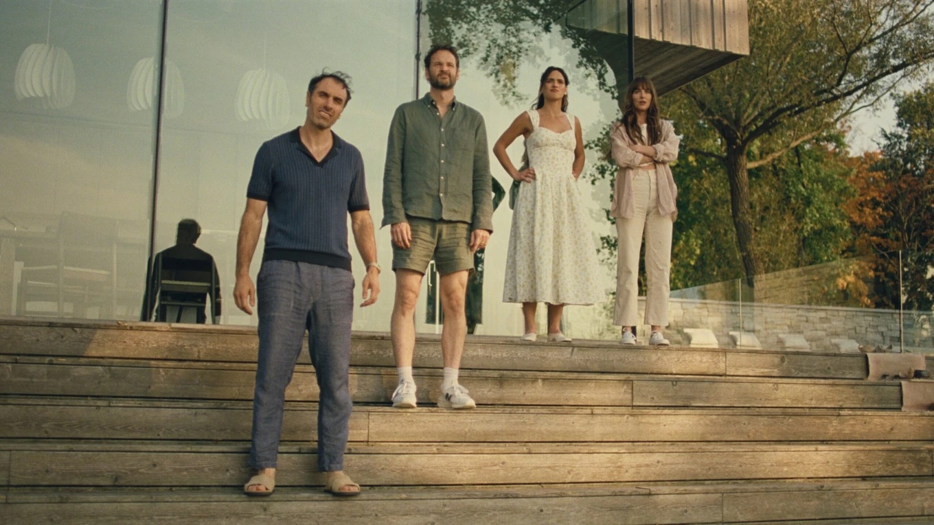 four people stand on stairs looking confused