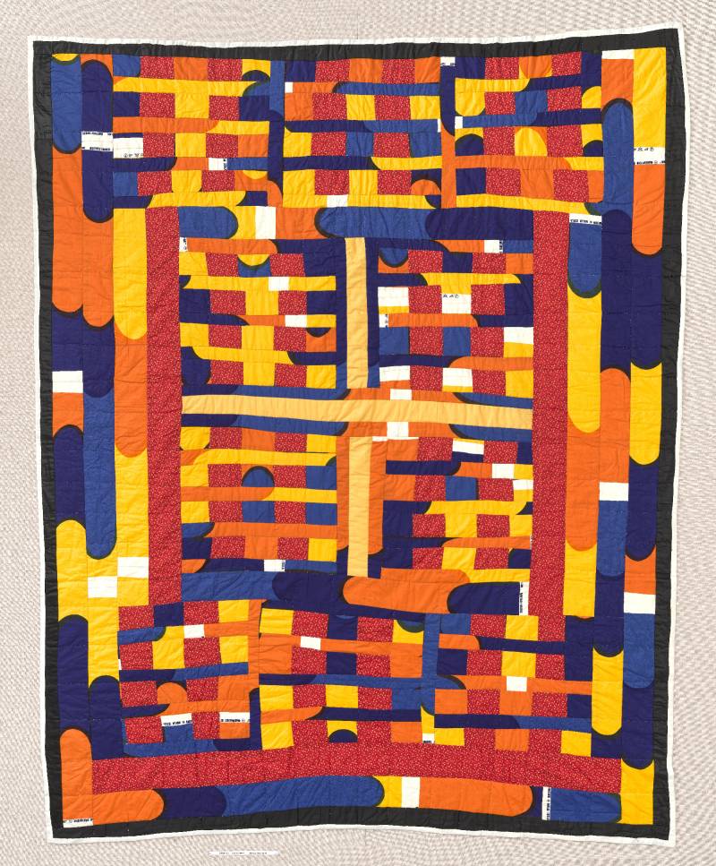 Bright red, yellow, orange and blue quilt with vertical and horizontal sections