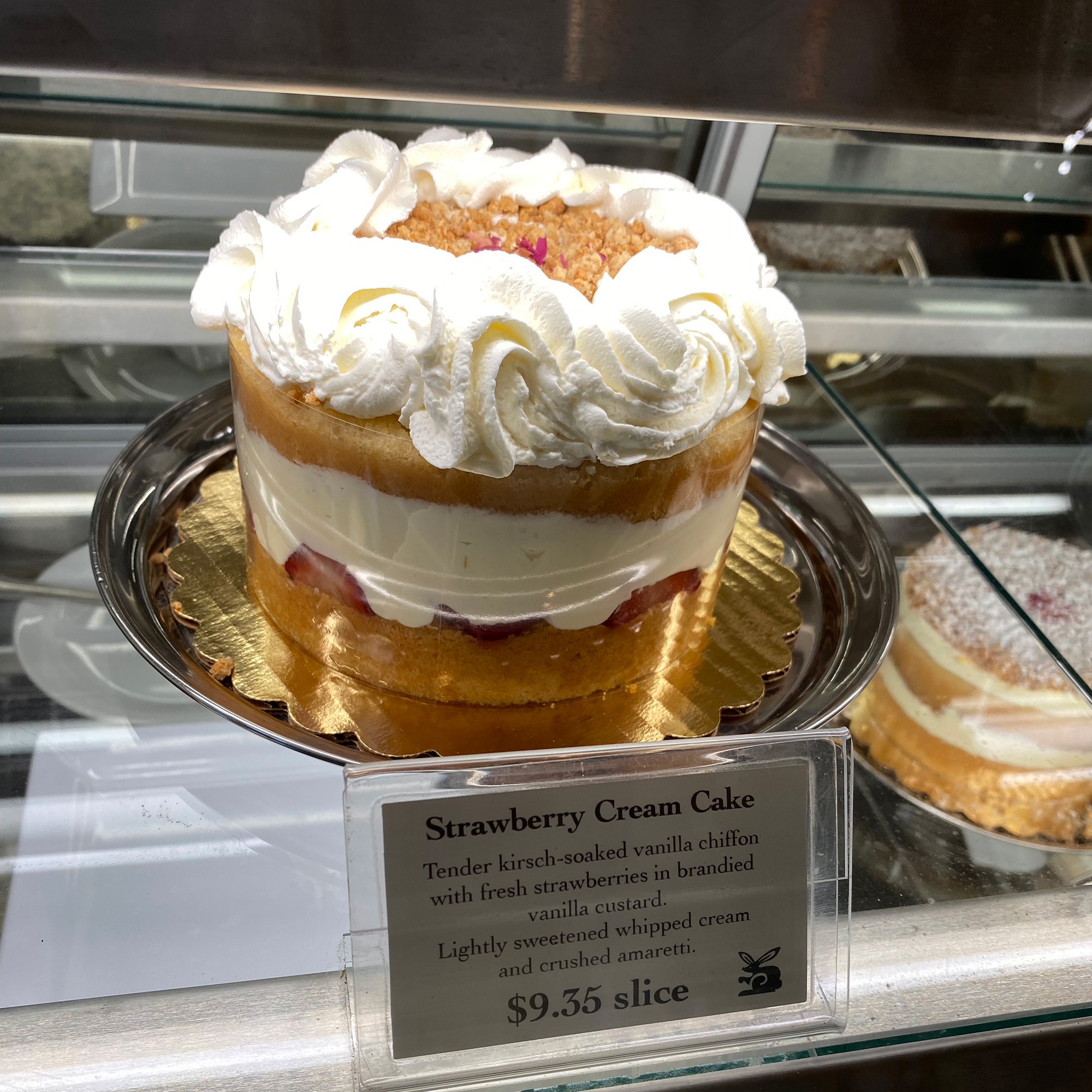 Strawberry cream cake inside a display case.