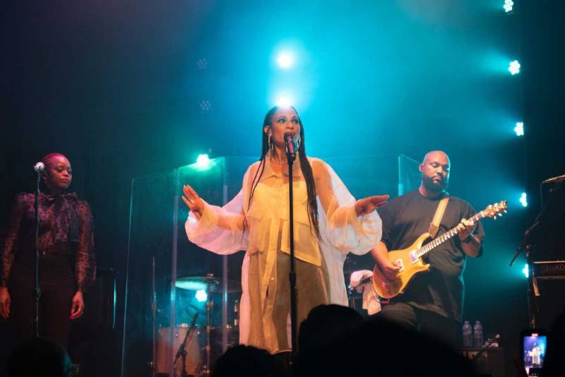 A woman on stage performing in front of a microphone. 