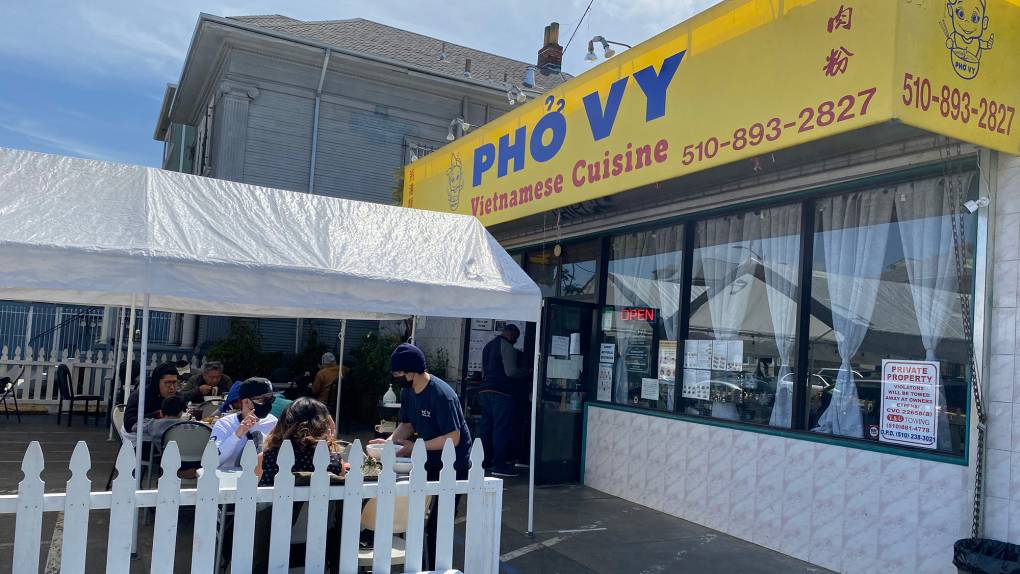 Exterior of a Vietnamese restaurant. The sign on the yellow awning reads, "Pho Vy."