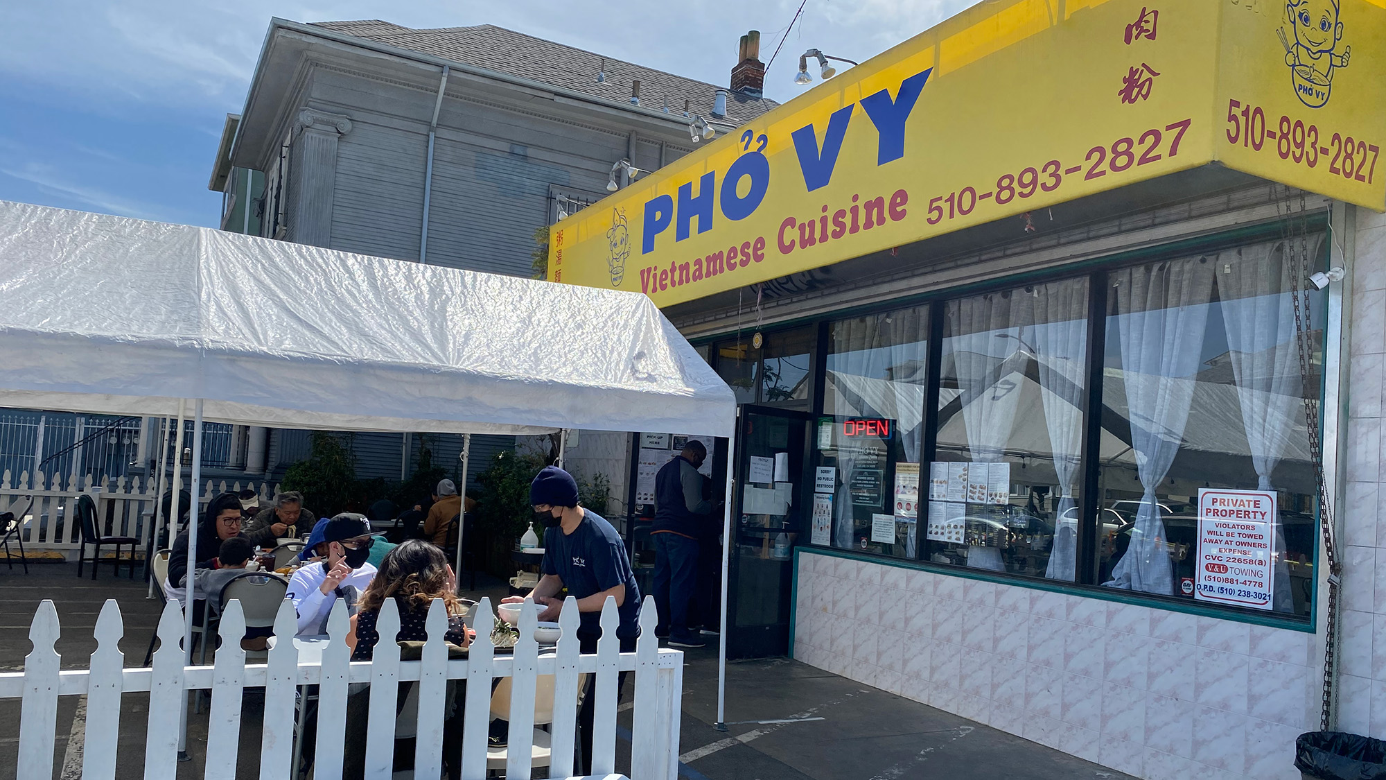 Exterior of a Vietnamese restaurant. The sign on the yellow awning reads, "Pho Vy."