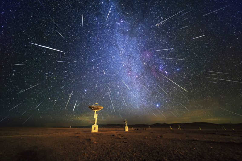 An image of a night sky at an observatory, in the middle of a meteor shower.
