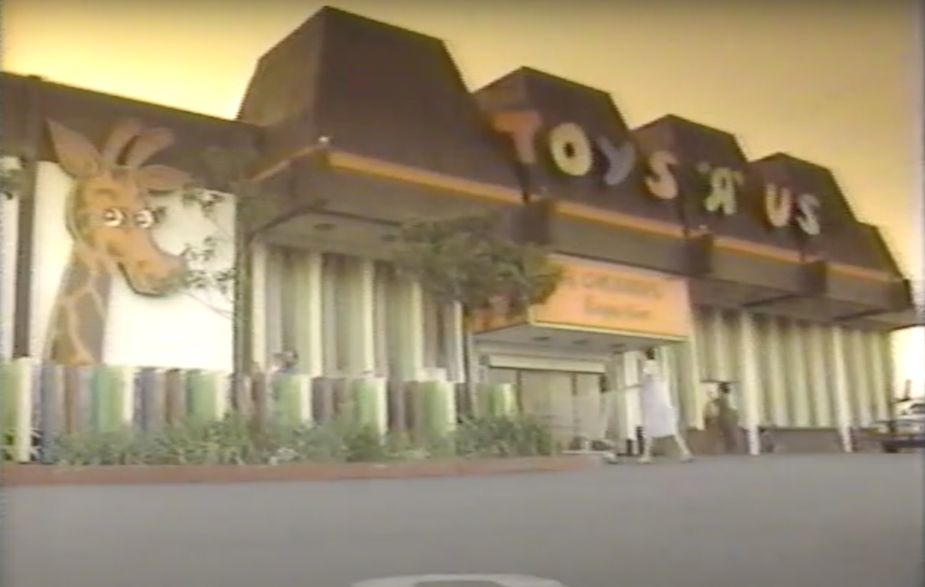 faded image of store with name across roofline, giant giraffe on facade