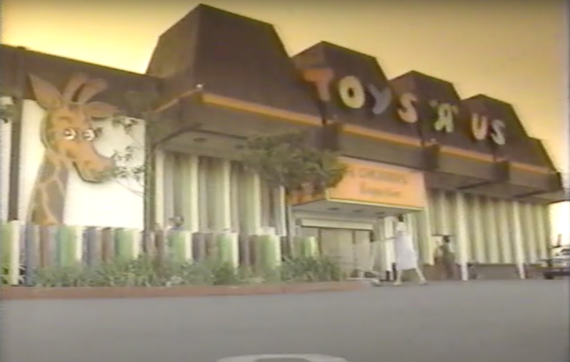 faded image of store with name across roofline, giant giraffe on facade