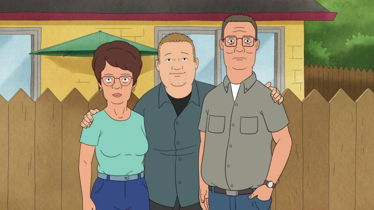 A still from an animated TV show of a young man standing in front of a wooden fence, with his arms around an older woman and man.