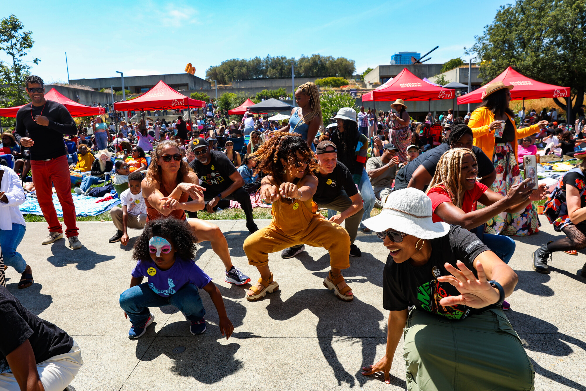 Dancers dancing onstage in an outdoor amphitheater.