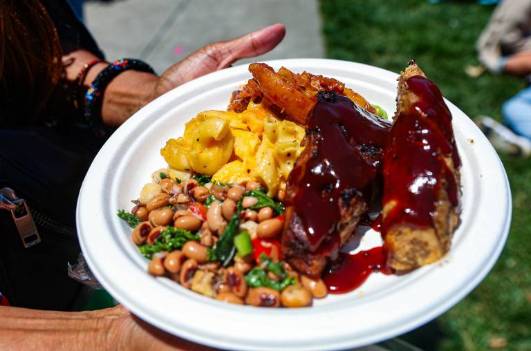 Paper plate with ribs, mac and cheese, and black-eyed pea salad.