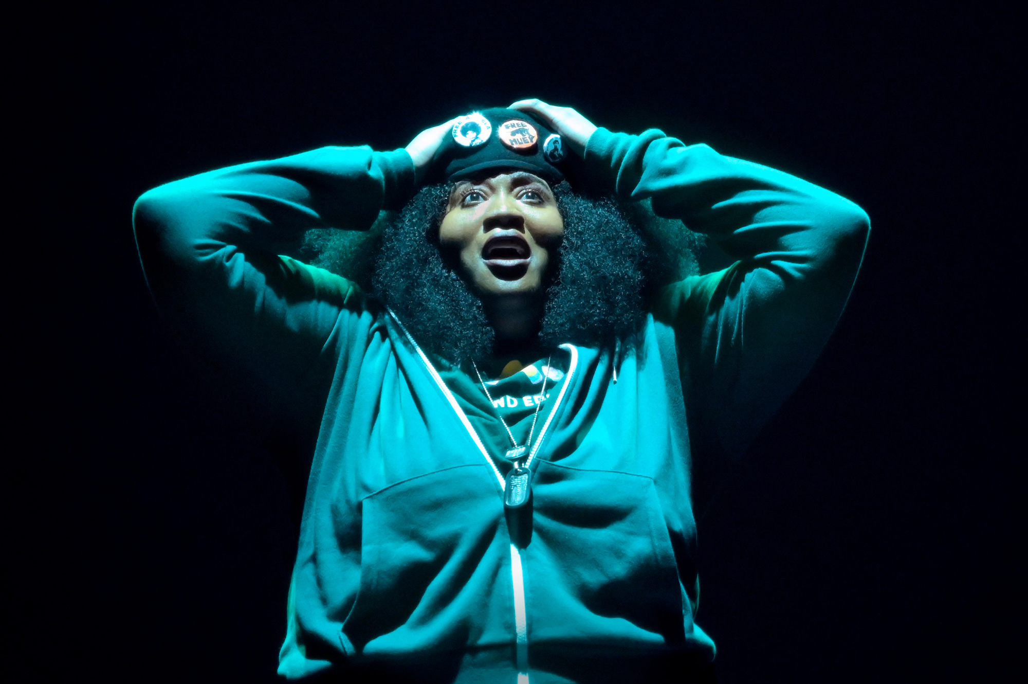 Black woman with hands on head under green light