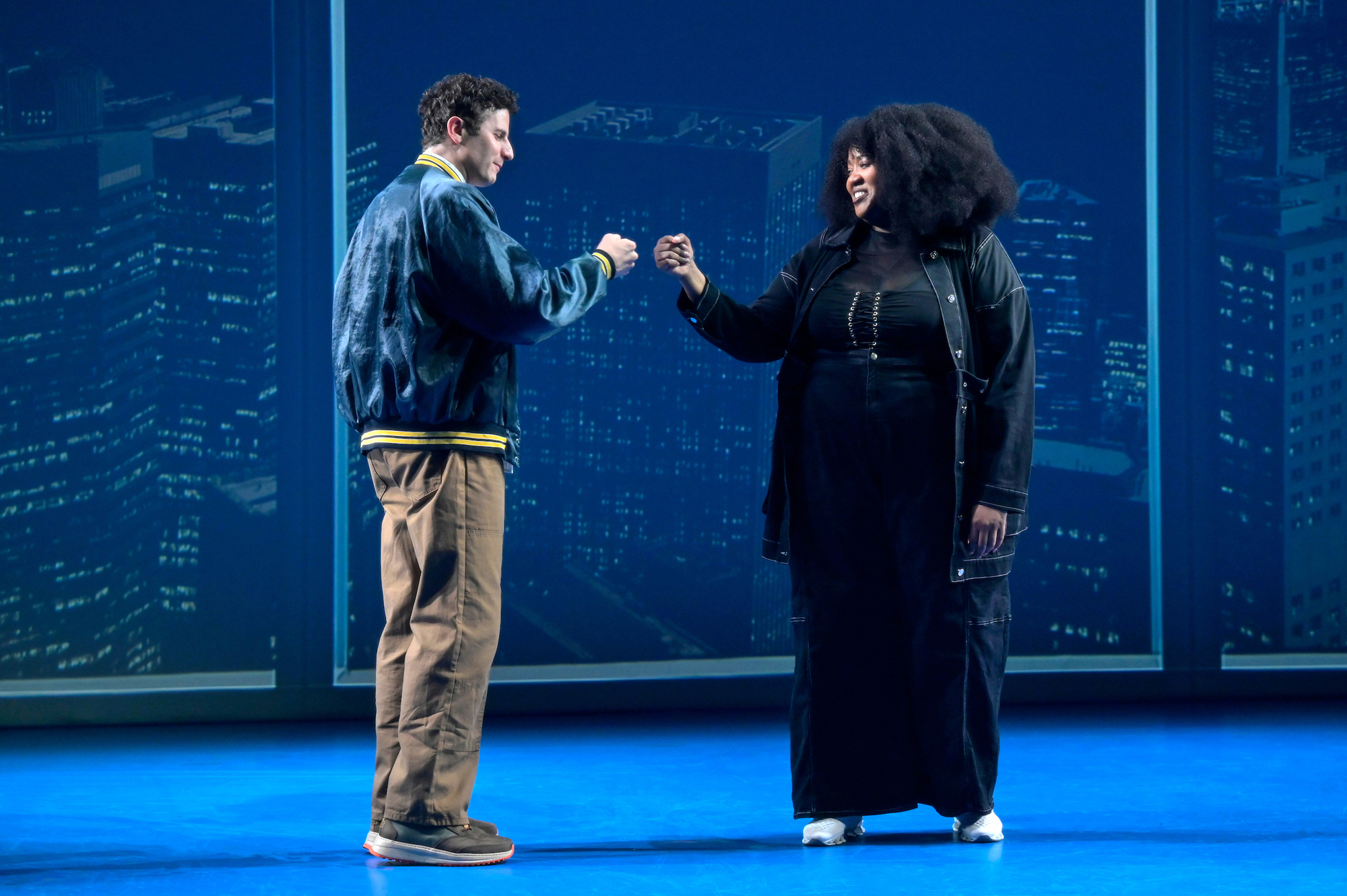 white man and Black woman bump fists on stage
