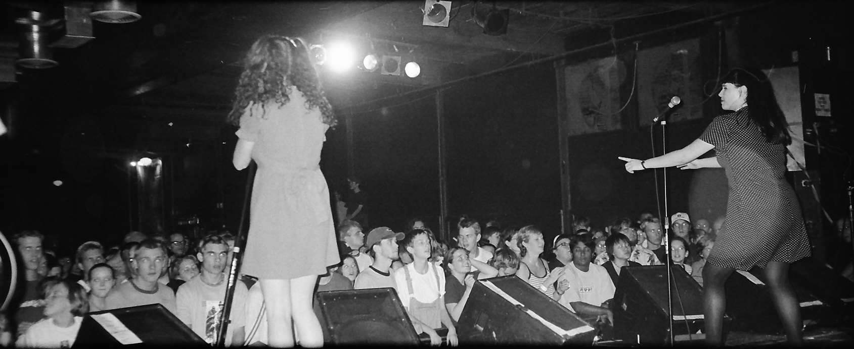 a black and white photo of a band on stage from the back