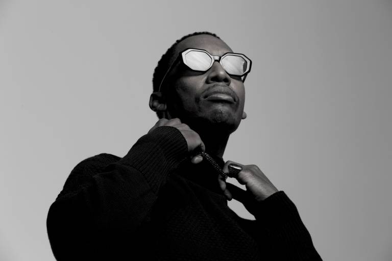 black-and-white iamge of Black man in reflective glasses, popping collar