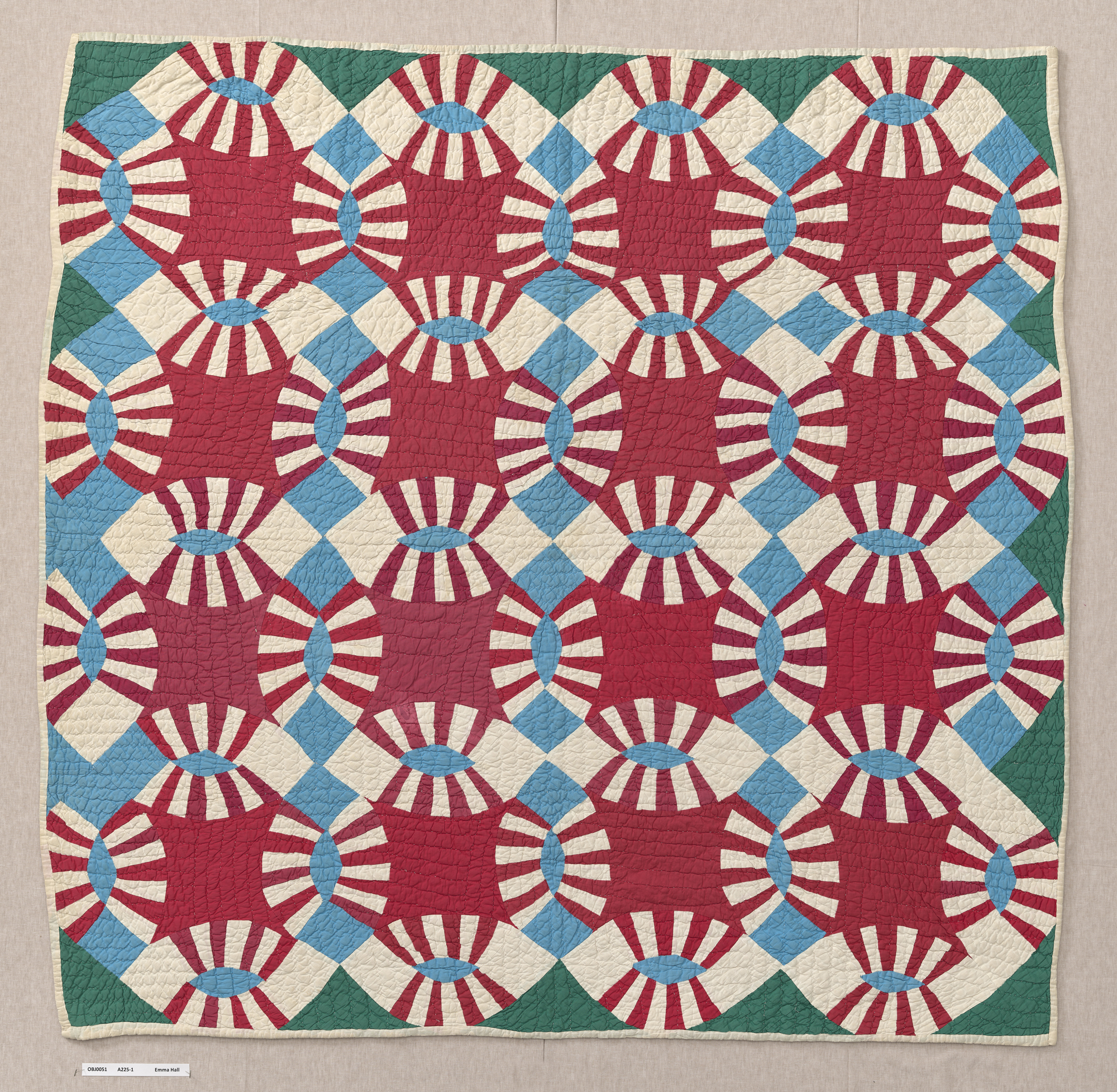 square quilt with double wedding ring pattern in red, white, blue and green