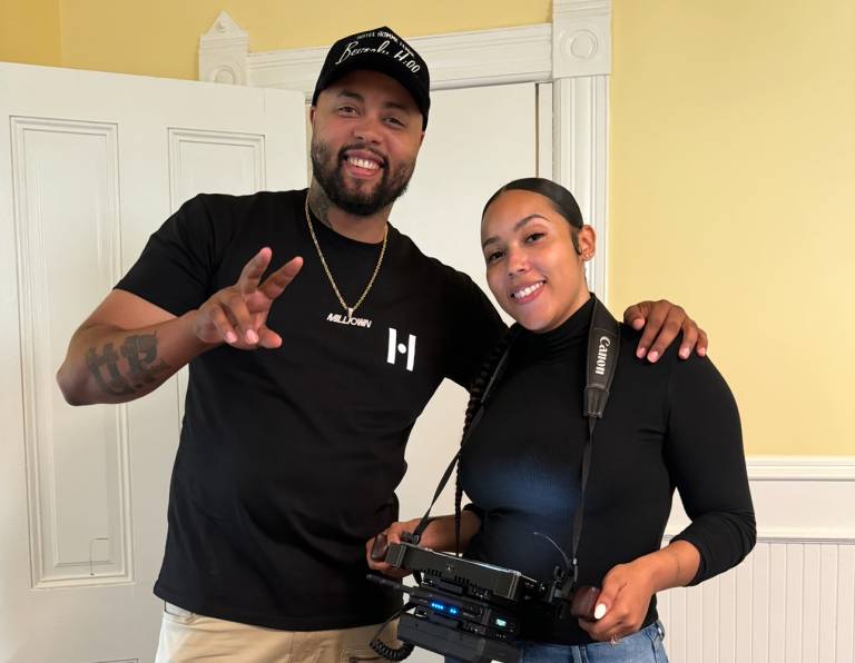 A man and a woman, both wearing black shirts, pose for a photo.