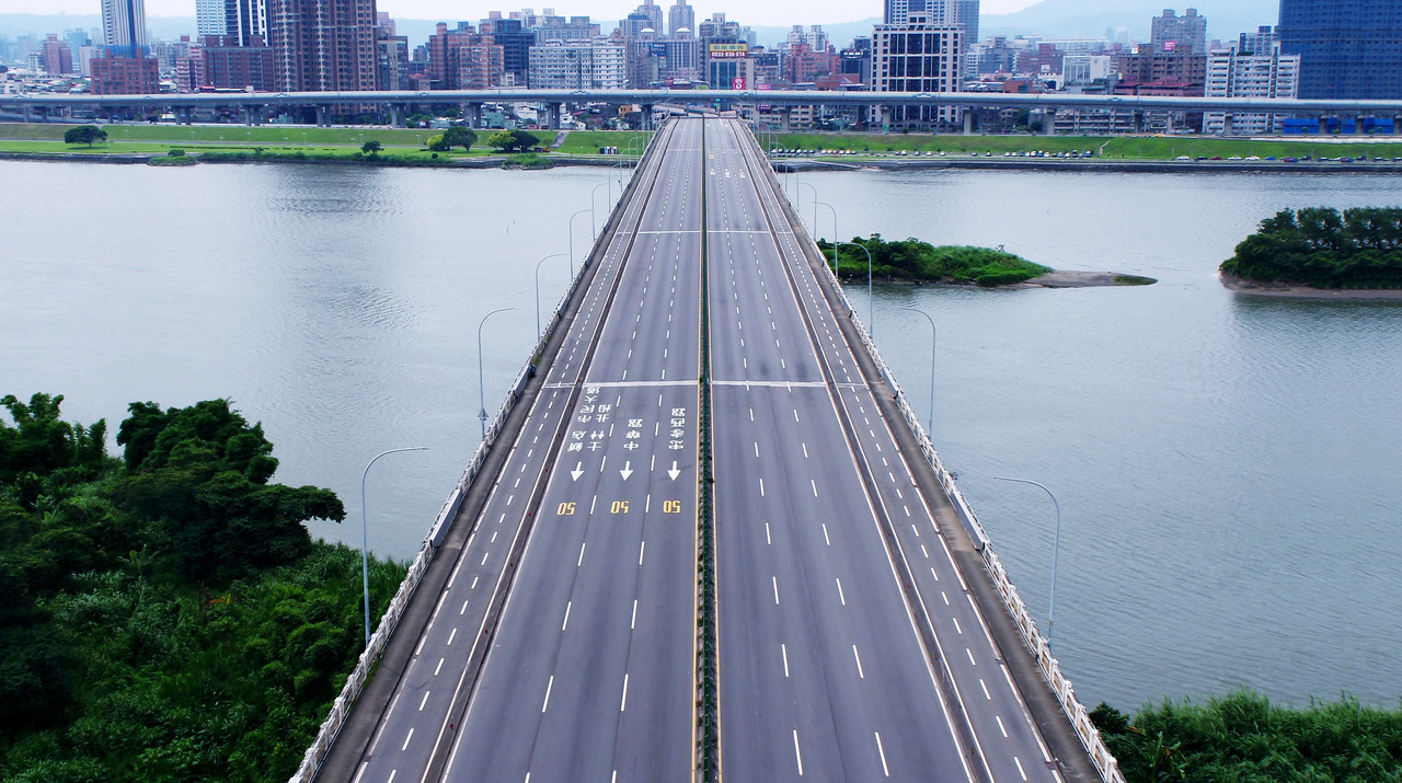 view of empty highway over water to city, seen from above