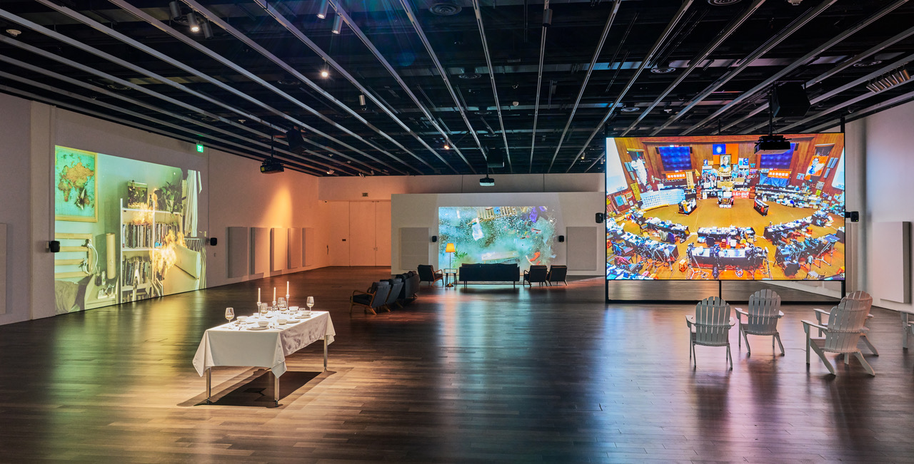 colorful images projected onto screens in large open gallery space