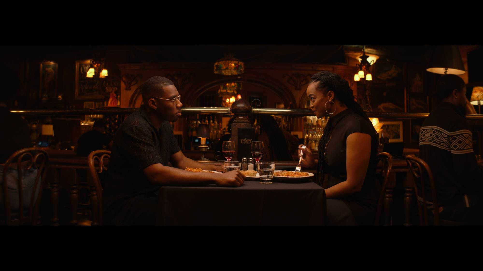 A photo of two people at a dimly lit restaurant.