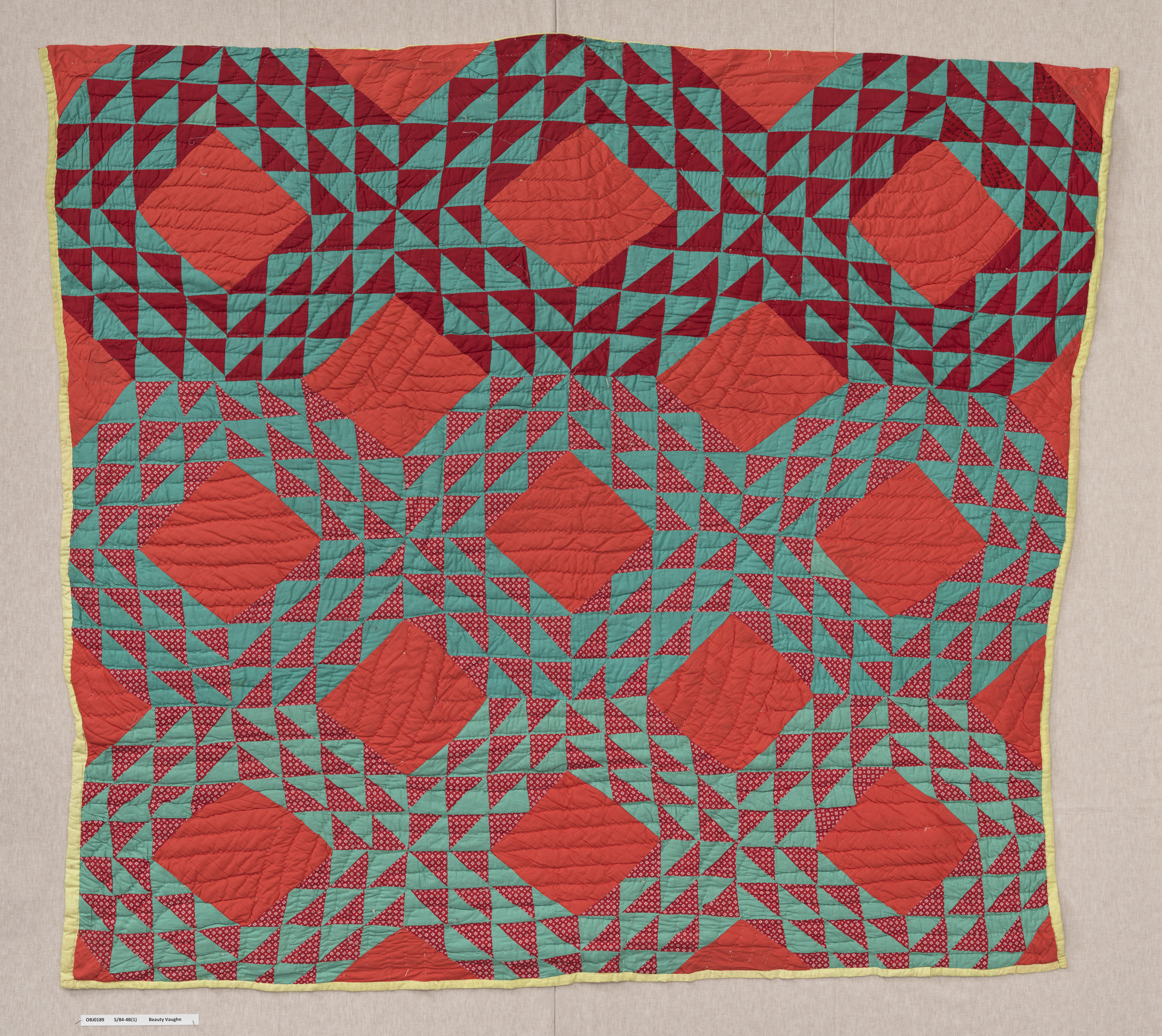 square quilt with vermillion diamond pattern and blue and red triangles surrounding