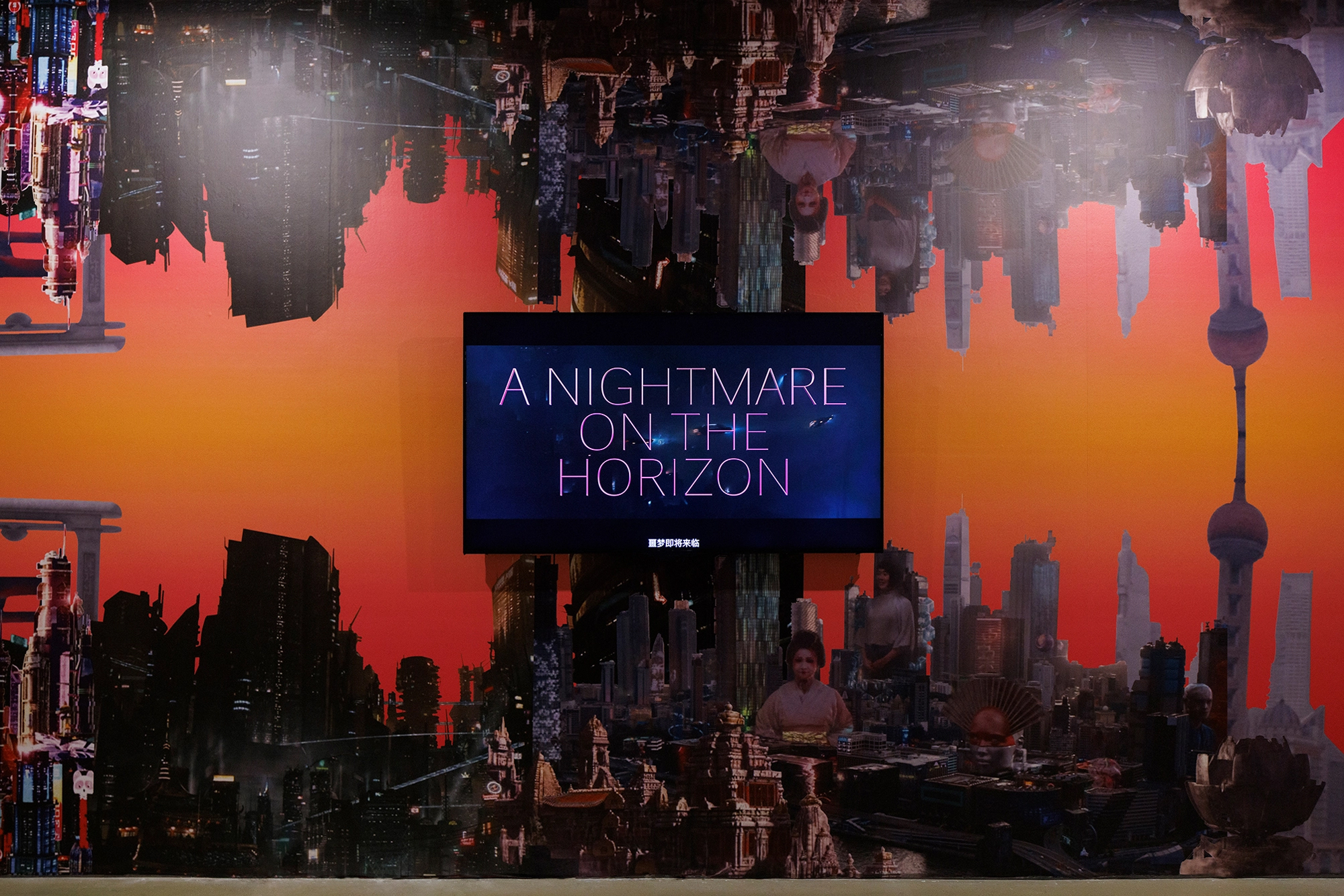 video screen against wall with two cityscapes against orange sky