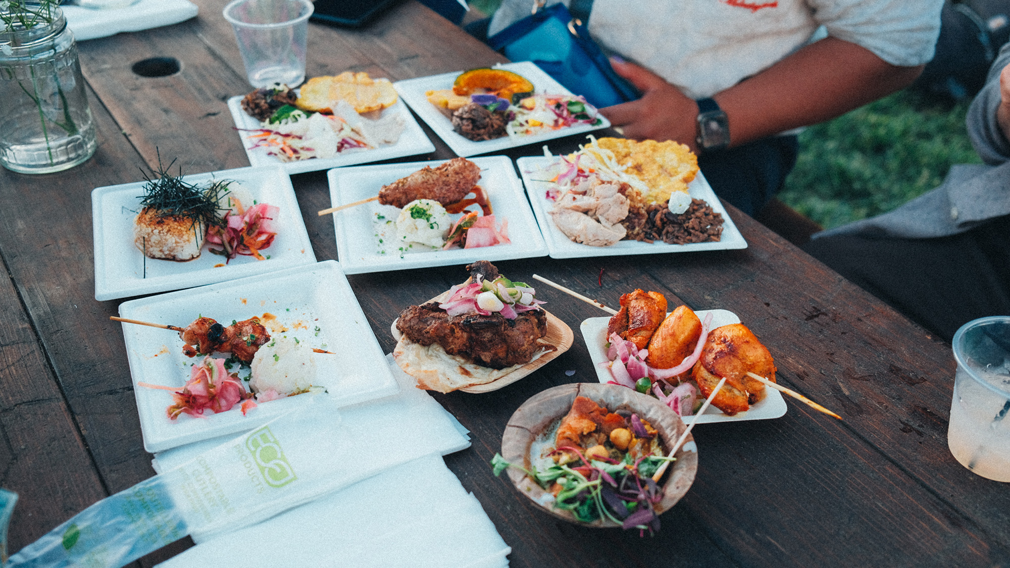A spread of grilled dishes laid out on a picnic table.