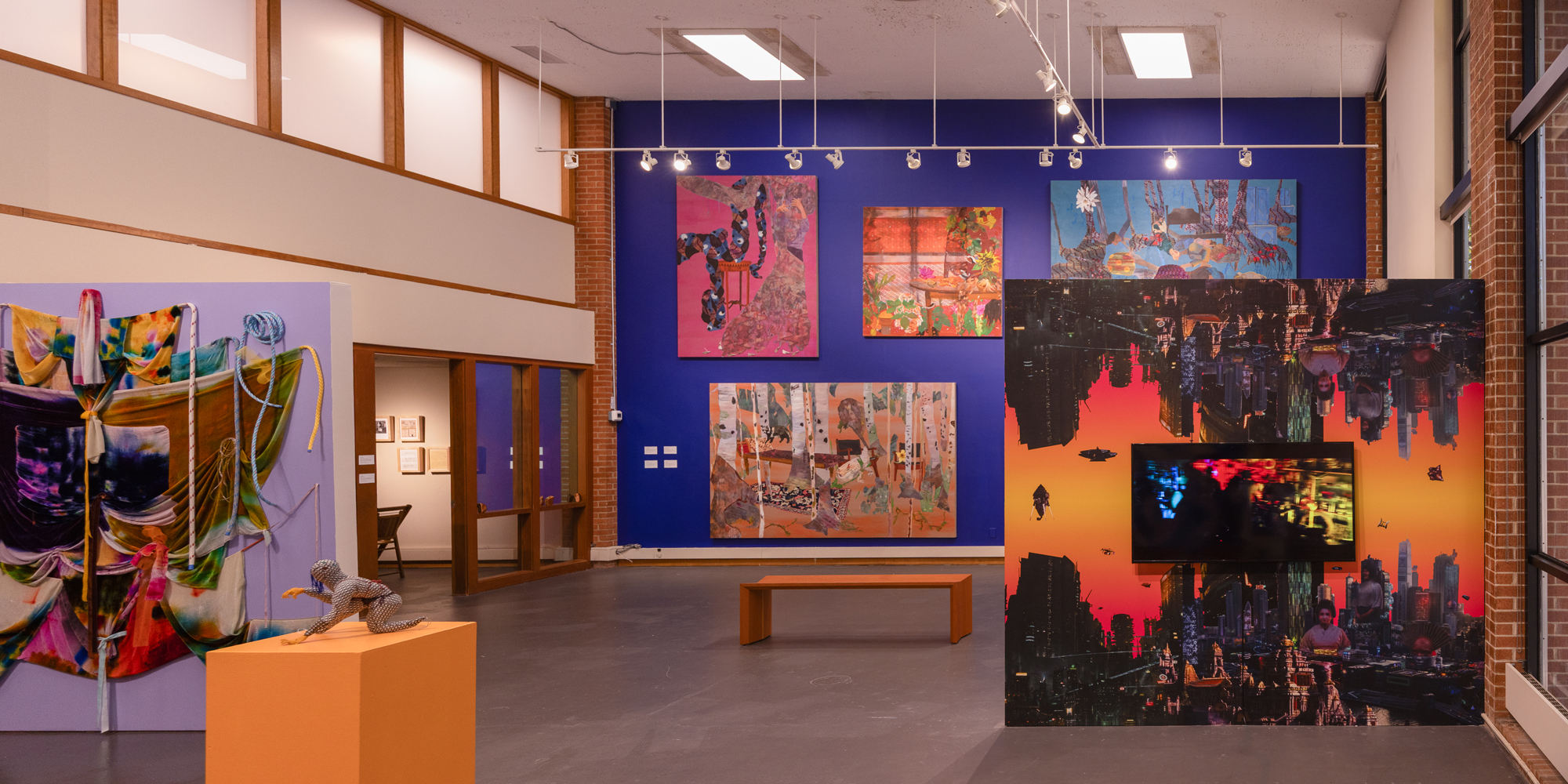 gallery view with colorful artworks, large paintings on far wall and video in foreground