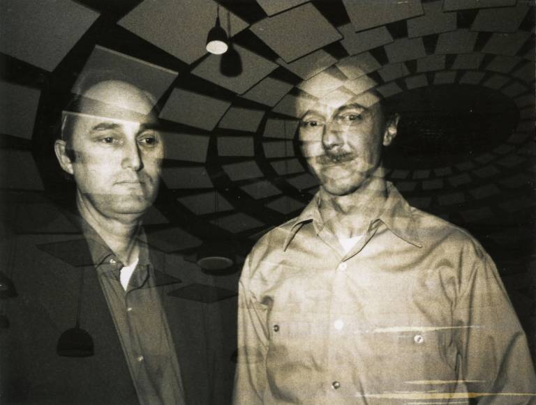 The image of two men superimposed against a backdrop of sound baffling