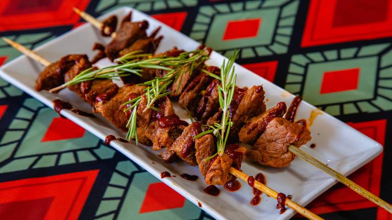 Saucy beef skewers garnished with rosemary
