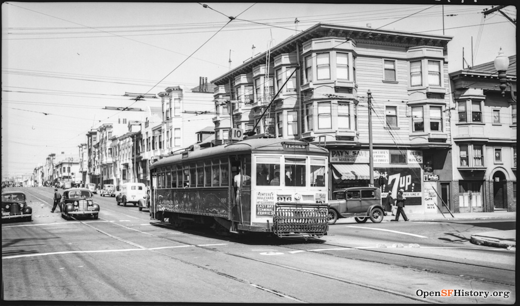 A black and white photograph of a 1930s-era streetcar traveling along a residential street in San Francisco.