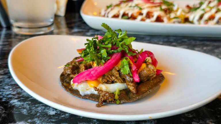Beef shawarma and pickled red onion, serve on a blue corn tostada.