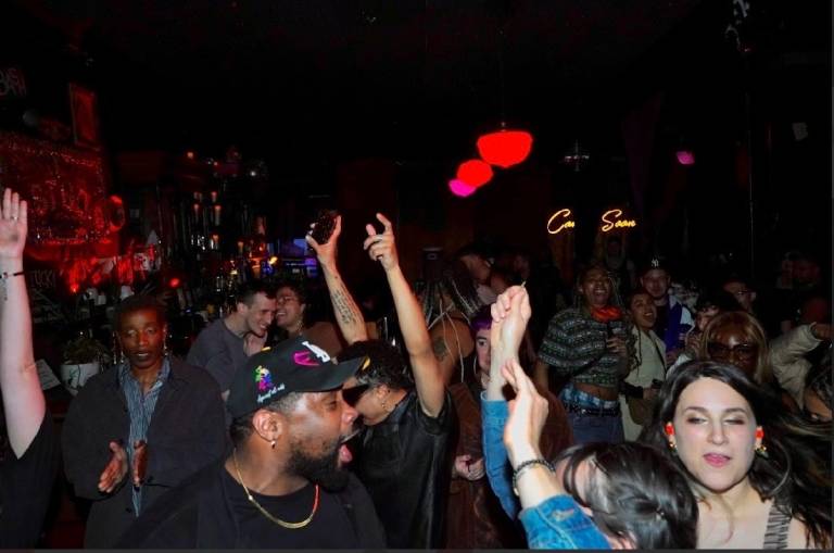 People dance inside a dark nightclub.