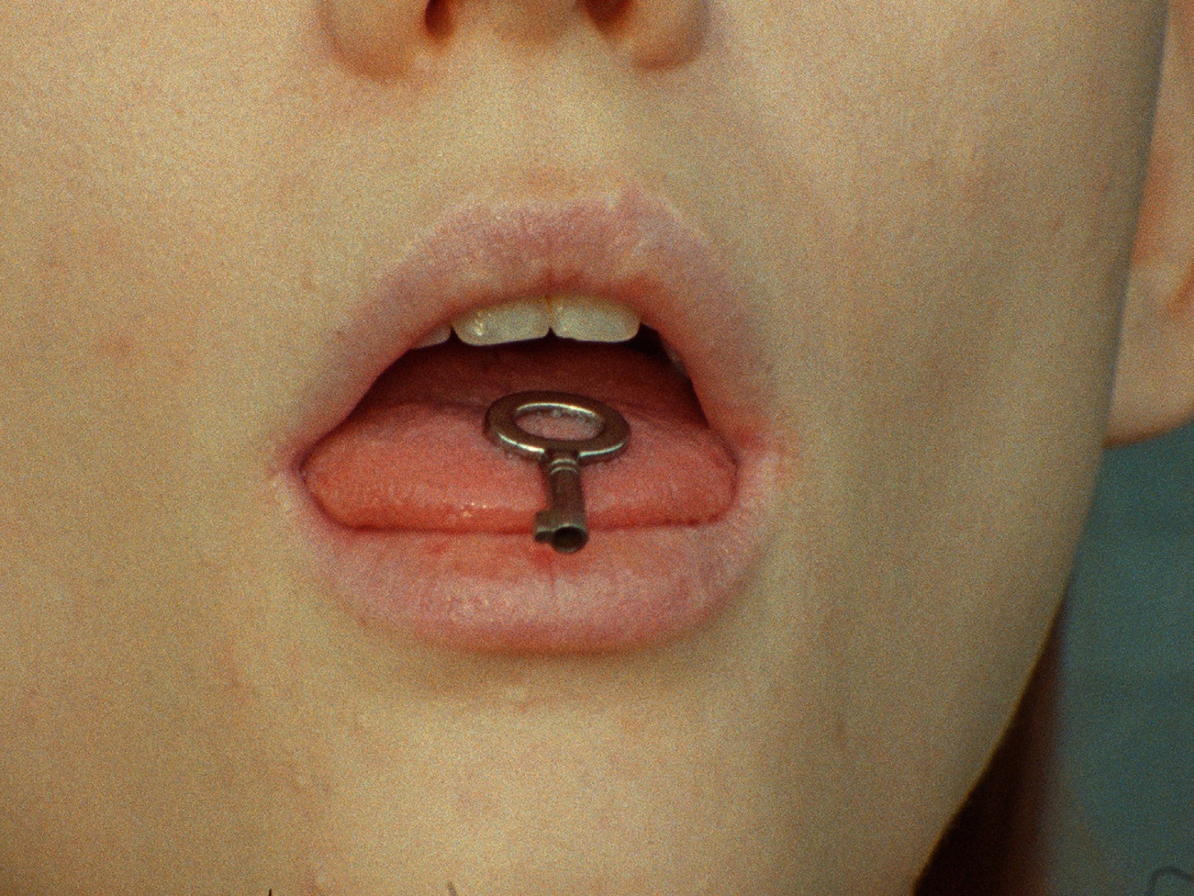 small key in person's mouth, on tongue