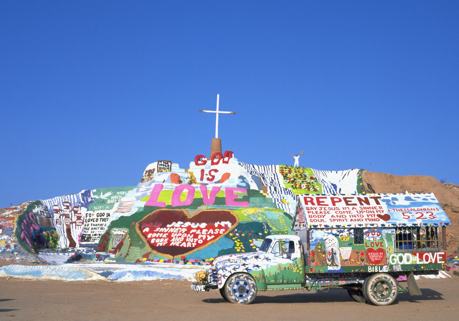 mound covered in painted slogans and crosses