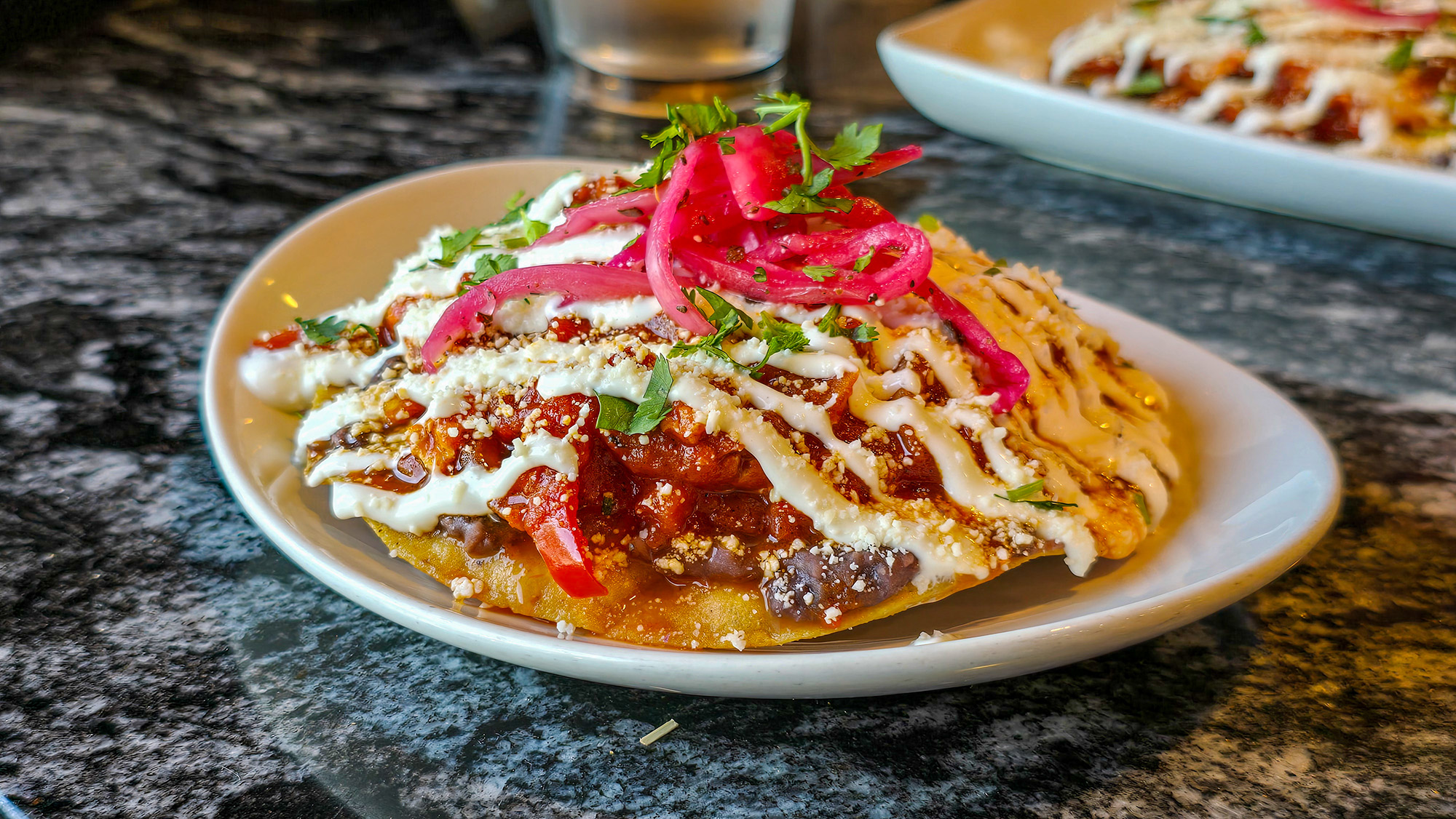 Tostada topped with egg cooked in tomato sauce.