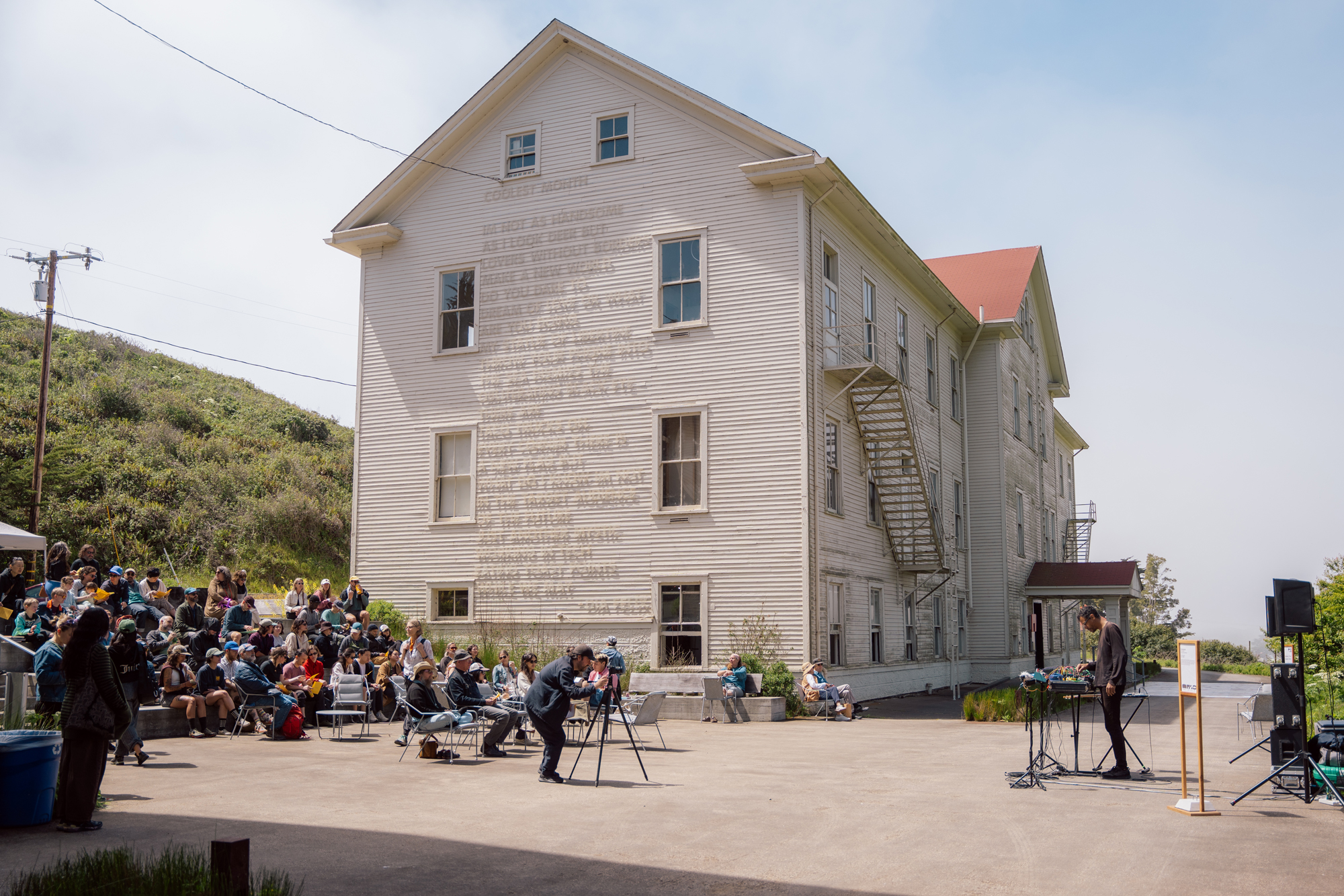 crowd seated on outdoor steps watching electronic music performance