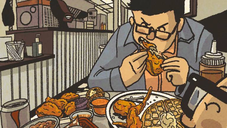 Illustration: two men devour fried chicken and waffles inside a restaurant.