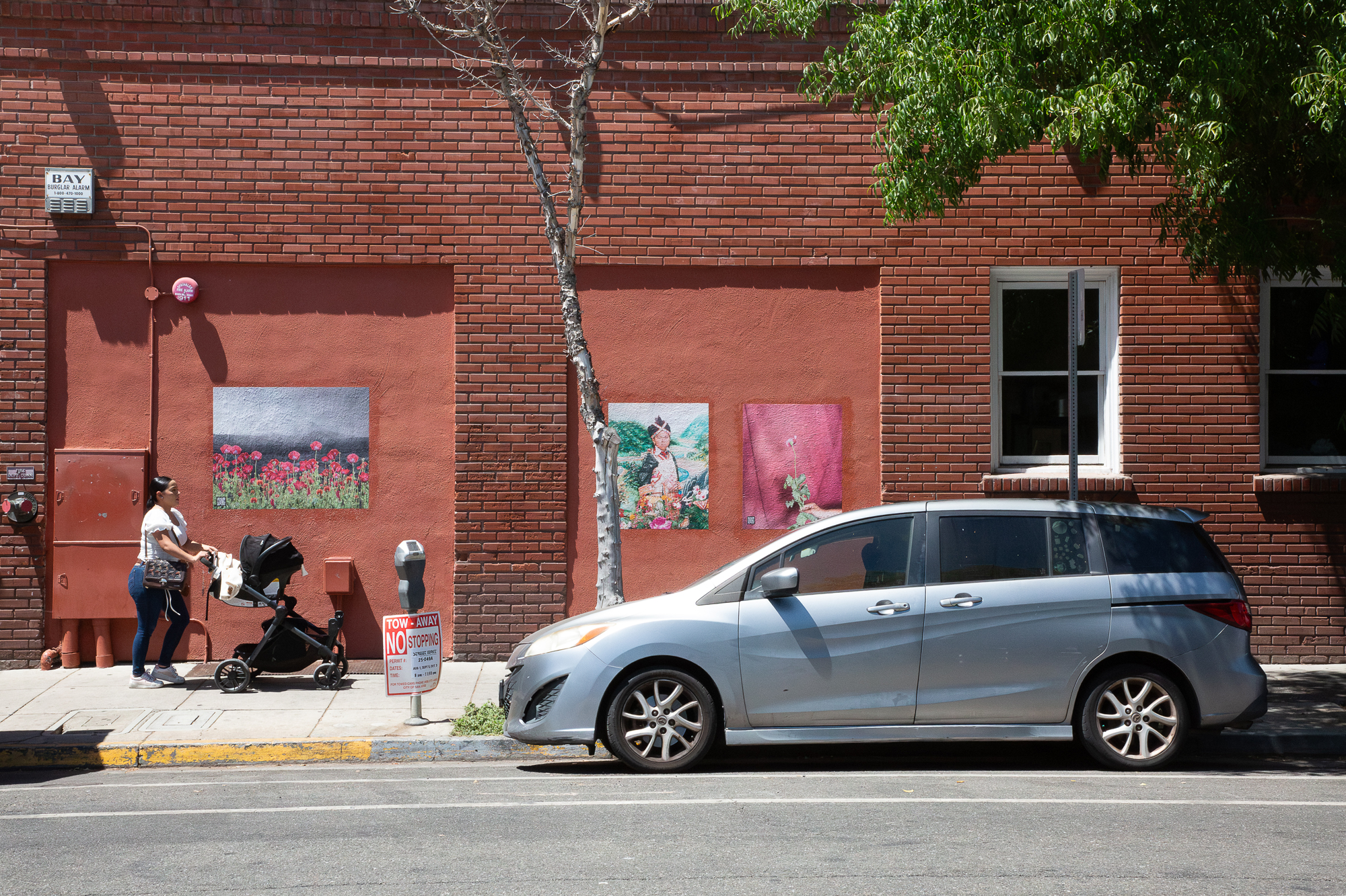color images on red wall with person pushing stroller by