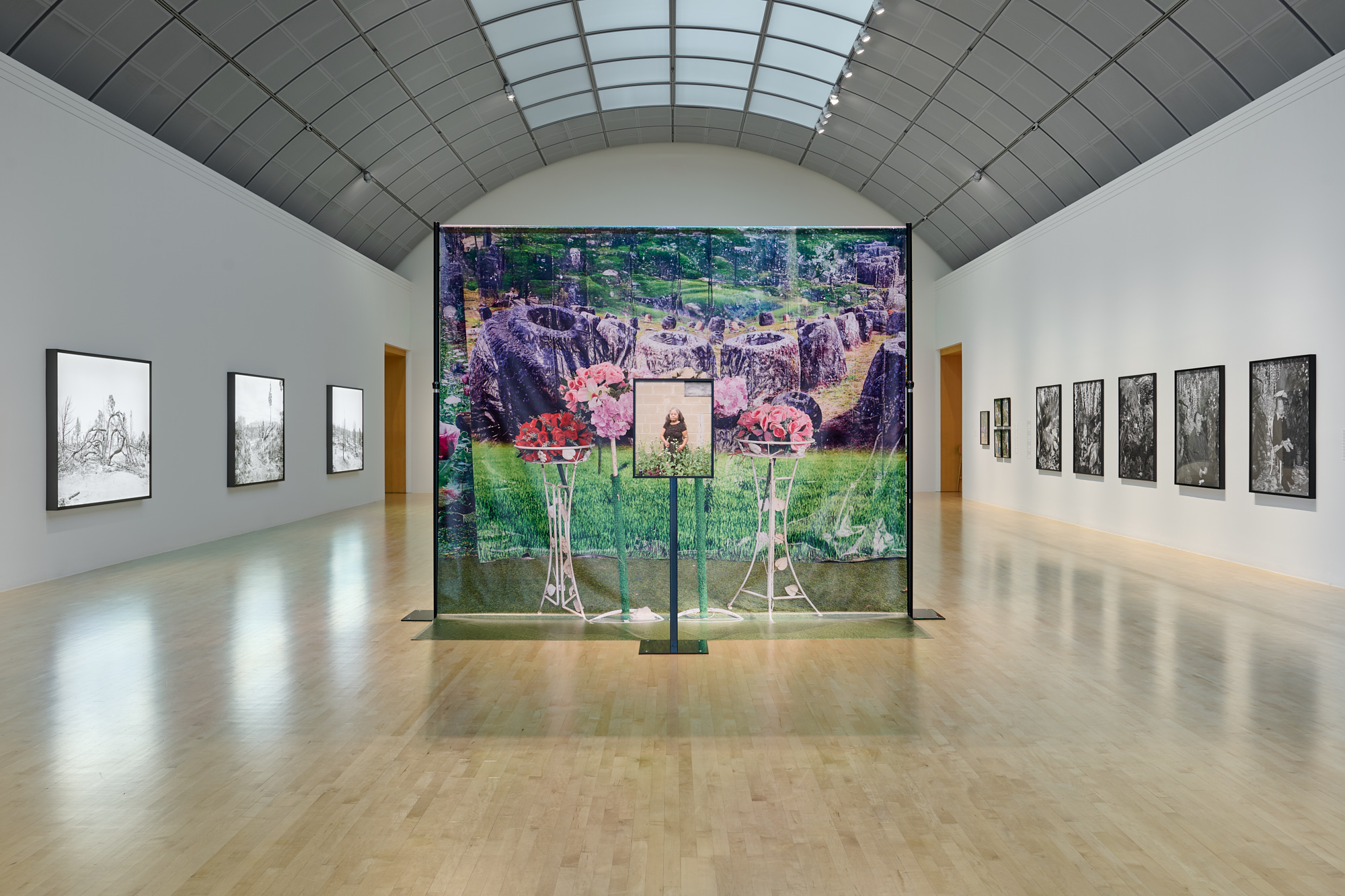large freestanding backdrop in gallery with small stand in front bearing portrait