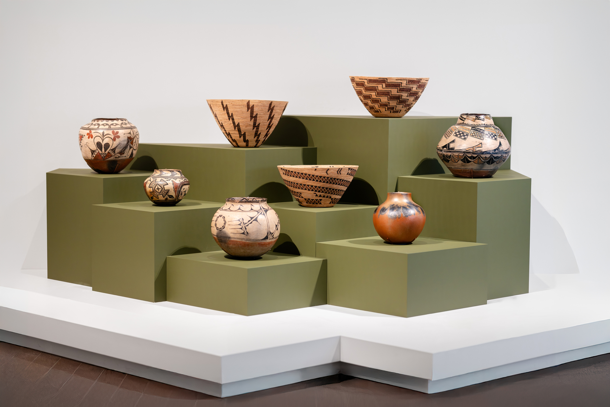 group of olive pedestals of varying heights with woven baskets on them