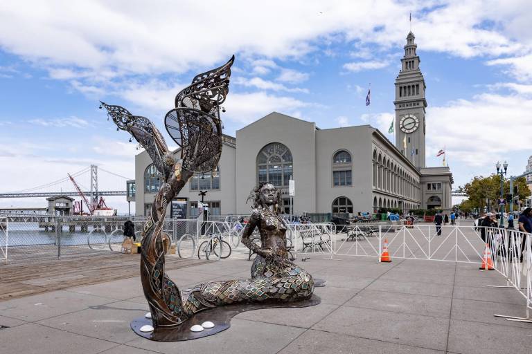 recycled metal sculpture of mermaid on waterfront