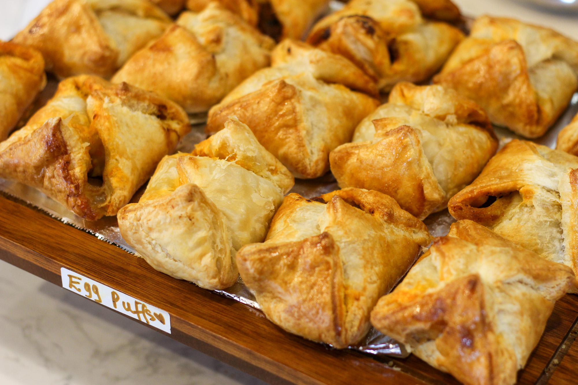 A display tray of crispy, golden-brown pastries labeled "Egg Puffs."