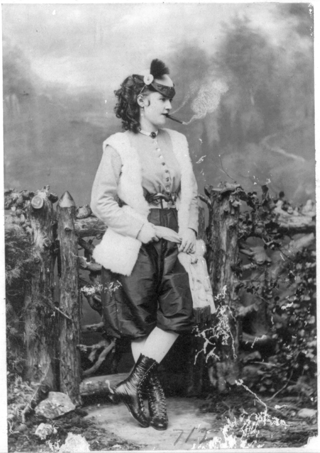 black-and-white image of women in pants smoking cigar