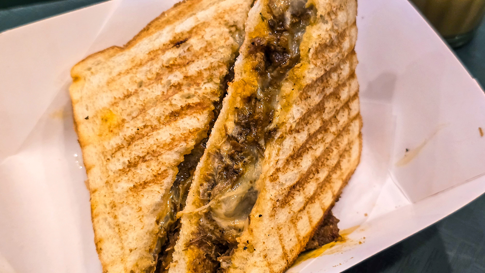 Toasted sandwich filled with saucy shredded beef.