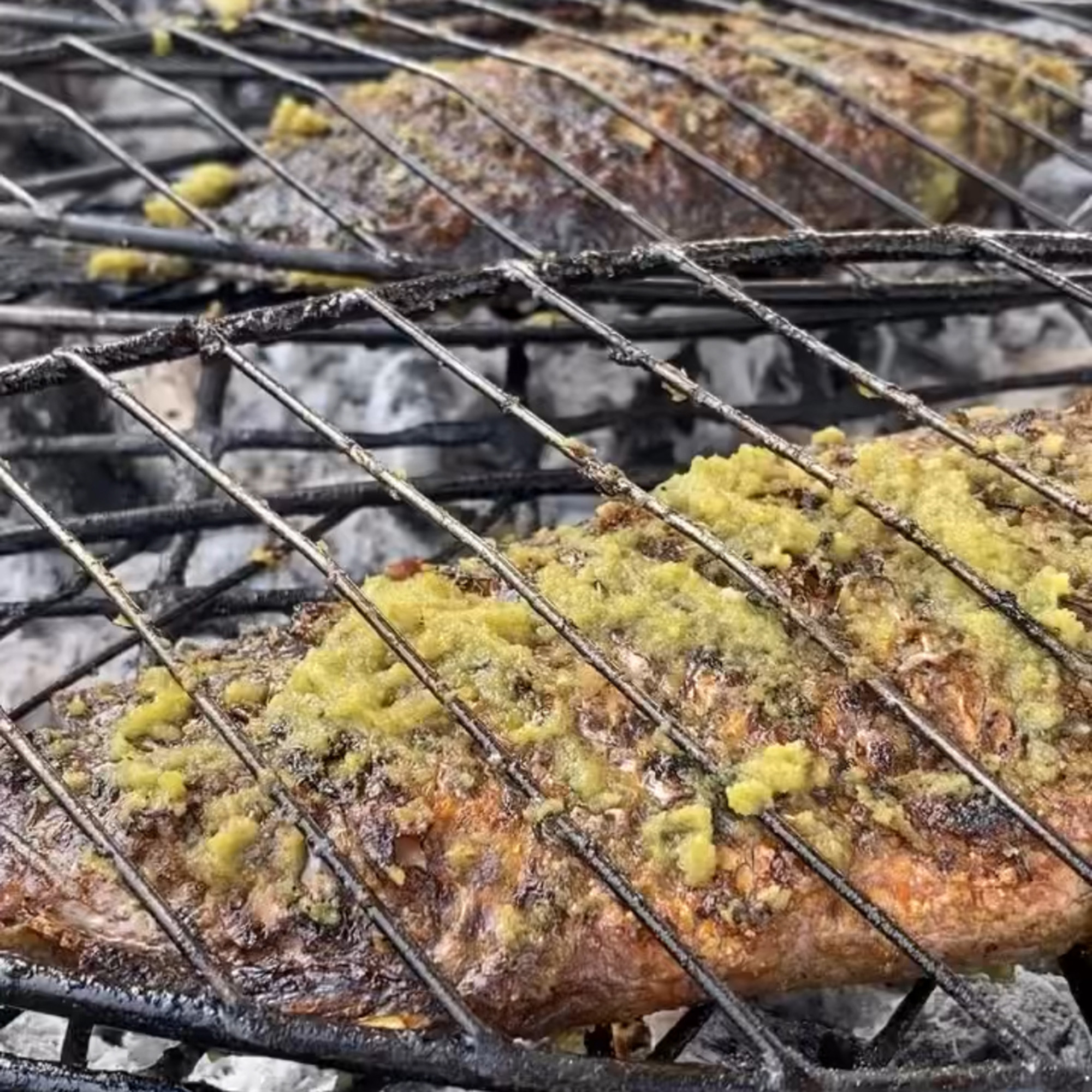 Whole fish cooking over hot coals.